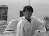Джеки Чан на фоне машины - картинка gif
