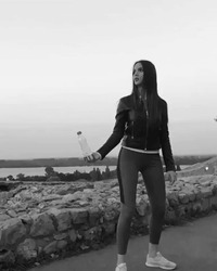 Девушка сбивает бутылку ударом ноги - картинка gif